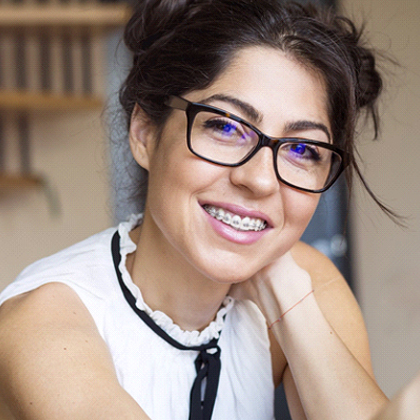 Closeup of woman smiling with traditional orthodontics