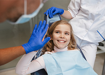 Child smiling and giving dentist a high five.
